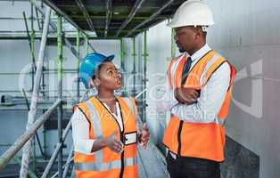 Combined skills are the building blocks of success. Shot of a young man and woman having a discussion while working at a construction site.