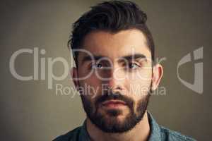 Excuse me, my eyes are up here. Closeup of a handsome young man posing against a grey background.