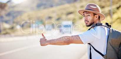 I need to find my way around. Shot of a young man hitchhiking on the side of the road.