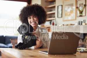 The dog is a gentleman. Shot of a young woman playing with her dog at home.