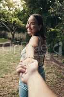 Our love is an adventure. Shot of an attractive young woman holding her boyfriends hand and leading the way while on an outdoor date.