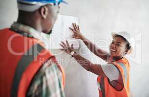 Theyve got their names cemented in the construction hall of fame. Shot of a young man and woman going over building plans at a construction site.