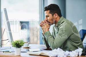 The best ideas take time. Shot of a focused young businessman seated behind his desk and contemplating inside of the office during the day.