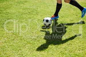 The art of dribbling. Shot of a young footballer dribbling the ball on a field.