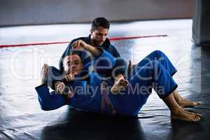 Take it to the mat. Full length shot of two young male athletes sparring on the floor of their dojo.
