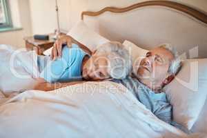 Ive listened to this heartbeat for years. Cropped shot of an affectionate senior couple cuddling each other while asleep in bed at a nursing home.