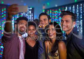 Theyve made it a night to remember. Cropped shot of a group of friends taking a selfie while partying in a club.