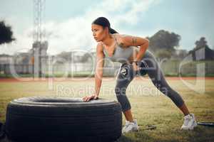 Building strength with every rep. Full length shot of an attractive young female athlete exercising with dumbbells outdoors.