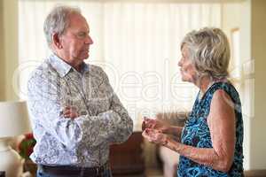 Breakdown in dialogue. Shot of a senior couple having an argument at home.