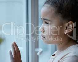 A forgotten child should be a punishable offence. Shot of a little girl starting out of the window looking sad at home.