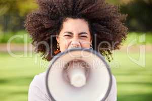 Never be afraid to raise your voice. Shot of a young woman screaming into a loudspeaker while protesting in the park.