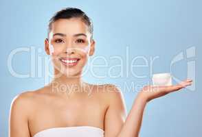 You wont find anything better than this for your skin. Studio portrait of an attractive young woman holding a beauty product against a blue background.