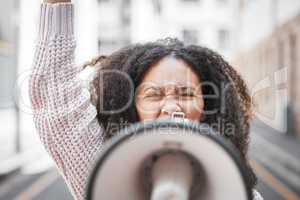 I raise up my voice. Shot of a young woman screaming into a loud speaker while protesting in the city.