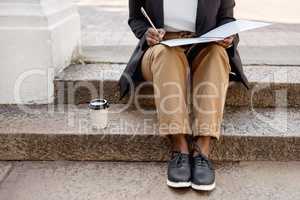 Planning for success, even in her spare moments. Closeup shot of an unrecognisable businesswoman going through paperwork while sitting on a staircase outdoors.