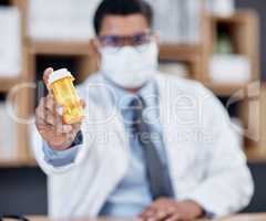 These meds come highly recommended. Closeup shot of an unrecognisable doctor holding a bottle of pills in his office.