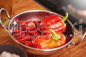 Some like it hot. Shot of a pan filled with red peppers and chillies on a tabletop.