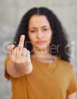 My attitude depends on how you treat me. Cropped shot of a young woman showing middle finger while standing outside.
