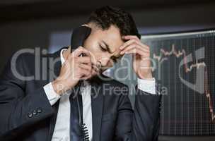 These markets better improve soon. Shot of a young businessman making a phone call in order to monitor the stock market.