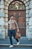Hes got business to attend to. Full length shot of a handsome businessman with a satchel about town.