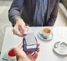 Has it gone through. Shot of a businessman using his debit card to pay for coffee.