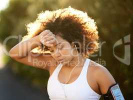 Working up a sweat. Shot of an attractive young woman wiping her brow during her workout.