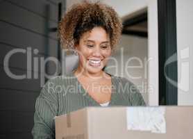 Ordering new decor for my castle. Shot of a young woman carrying a box at home.