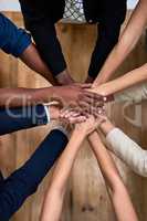 Teamwork brings out our best. High angle shot of a group of unidentifiable businesspeople piling their hands in unity in the office.