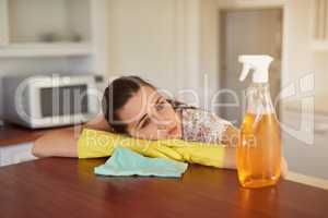 Theres just too many chores to do. Shot of a tired looking young woman leaning on a kitchen countertop.