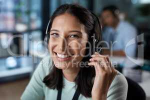Our customers are our first concern. Portrait of a young woman using a headset in a modern office.
