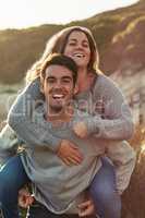 What a perfect day to be together. Portrait of a young couple relaxing on the beach together on the weekend.