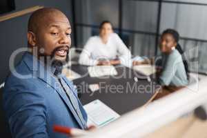 Heres the plan that I want everyone to follow. Shot of a mature businessman using a whiteboard during a presentation to his colleagues in an office.