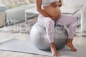 Every mom-to-be should get a stability ball. Cropped shot of a pregnant woman sitting on a stability ball at home.