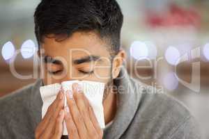 I have to get a diagnosis. Shot of a young man blowing his nose.