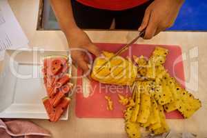 Theres precision in every incision. Shot of an unidentifiable chefs hands as she cuts fruit in the kitchen.