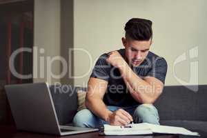Working hard to distinguish himself from the rest. Shot of a driven young man using his laptop to work from home.