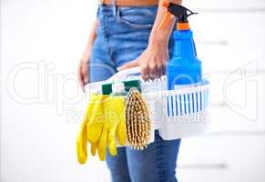 Lets get this cleaning done. Shot of a woman holding a basket of cleaning supplies.