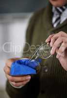 Theyre as good as new now. Shot of an unrecognizable person cleaning their glasses at work.