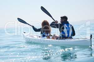 Theyre in their element. Rearview shot of a young couple kayaking together at a lake.