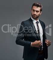 He knows how to pull off an outstanding first impression. Studio shot of a handsome young businessman posing against a grey background.