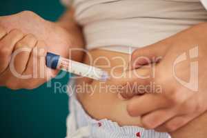 The body knows when insulin is required. Closeup shot of an unrecognizable woman injecting herself in the stomach with insulin at home.