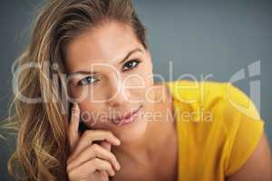 Confidence is silent, insecurities are loud. Shot of a young woman posing against a gray wall.