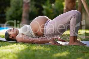 Low-impact exercises are great for women in their third trimester. Shot of a pregnant woman doing yoga outside.