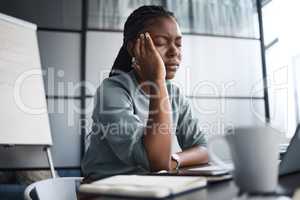 I should take a painkiller for this. Shot of a young businesswoman looking stressed out while working on a laptop in an office.