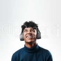 Another mind stimulating podcast from my favourite. Studio shot of a young man using headphones against a grey background.