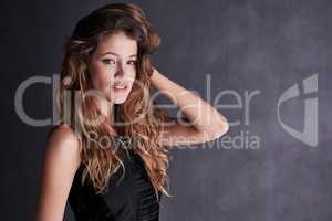Her beauty captivates all. Studio portrait of a seductive young woman posing against a dark background.