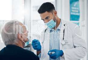 Its gonna be a little uncomfortable. Cropped shot of a handsome young male doctor testing a senior patient for covid.