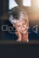 Maybe its time to pack it in. Shot of a mature businesswoman experiencing strain during a late night at work.