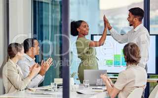 By failing to prepare, you are preparing to fail. Shot of a young man and woman high fiving one another in a meeting in a modern office.