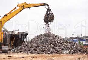 Industrial re-purposing. Cropped shot of an excavator sorting through a pile of scrap metal.