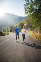 Were in it for the long run. Shot of a sporty couple out running on a mountain road.